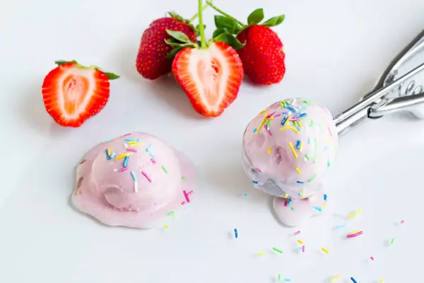 草莓冰淇淋是用冰淇淋勺和新鲜草莓制成的 图库图片