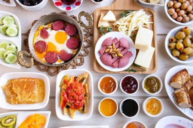 Geleneksel Türk Kahvaltısı ahşap masada bakır yumurta tavası ve beyaz tabaklar ile