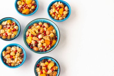 Geleneksel Türk Tatlısı ya da beyaz yüzeyde seramik kaplarda Nuh 'un Pudingi. Türk Mutfağı