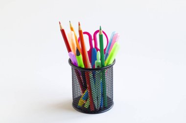 Renkli ofis veya okul gereçleri beyaz yüzeyde siyah metal bir kalem kutusunda fotokopi alanı ile