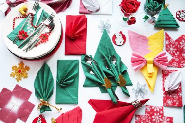 Yeni yıl peçeteleri farklı renkte ve şekillerde beyaz bir yüzeyde çatal bıçak takımı ile tasarlandı..