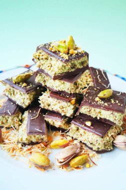 Dilimlenmiş Dubai Çikolatası, şam fıstığı ve kunefe ile beyaz tabakta.