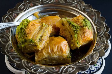 Traditional Turkish Pastry Dessert Baklava in vintage bowl on black surface clipart