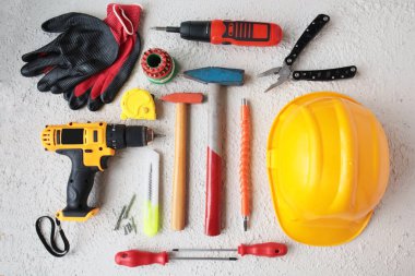 Sarı başlık ve küçük matkapla tasarlanmış renkli el aletlerinin üst görünümü.