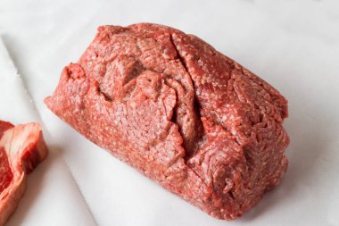 Bir kilogramın üstünde, yağsız, pişmemiş sığır eti, pişirme kağıdı üzerinde.