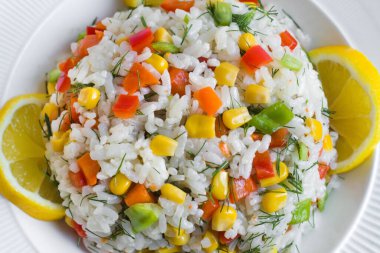 Pirinç salatası veya Asya mutfağından renkli sebzelerle pilav dilimlenmiş limonla servis edilir.