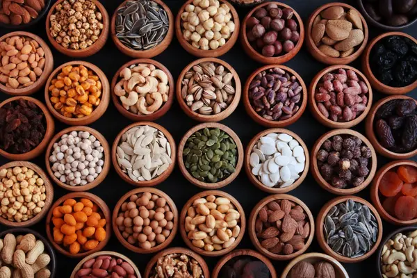 Çeşitli lüks fındıklar siyah bir yüzeyde bambu kaselerinde tasarlandı. Büyük bir grup.