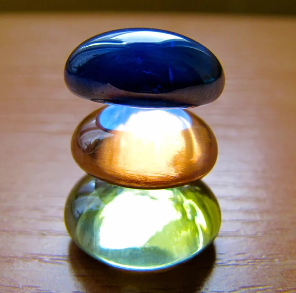     three colored glass stones stacked on top of each other                          
