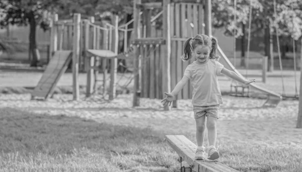 Little girl walks on a play on the park