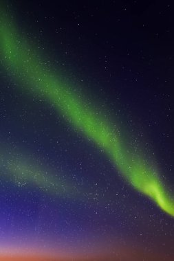 Gece mavi yıldızlı gökyüzü ve kuzey ışıkları. Yeşil aurora borealis