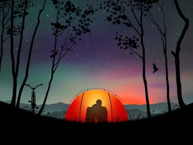 Çift turuncu çadırda oturur. Gece karanlığında dağlarda kamp yapmak