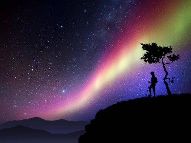Kadın dağın tepesindeki ağacın altında duruyor. Yıldızlı gökyüzünde renkli aurora