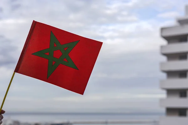 stock image Hands with flags of Morocco with defocused background cheering for their soccer team in the world cup.