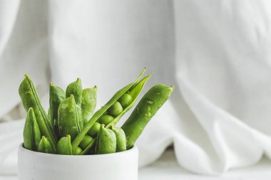 Hafif arka planda çiğ bezelye kabukları. Sağlıklı gıda konsepti