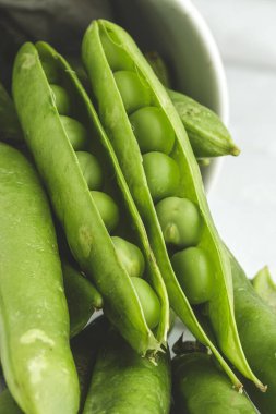 Hafif arka planda çiğ bezelye kabukları. Sağlıklı gıda konsepti
