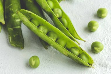 Hafif arka planda çiğ bezelye kabukları. Sağlıklı gıda konsepti