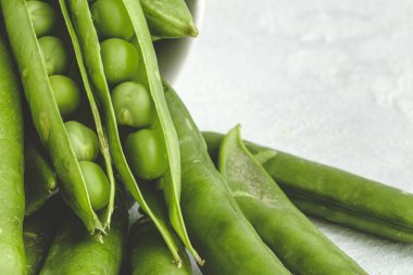 Hafif arka planda çiğ bezelye kabukları. Sağlıklı gıda konsepti