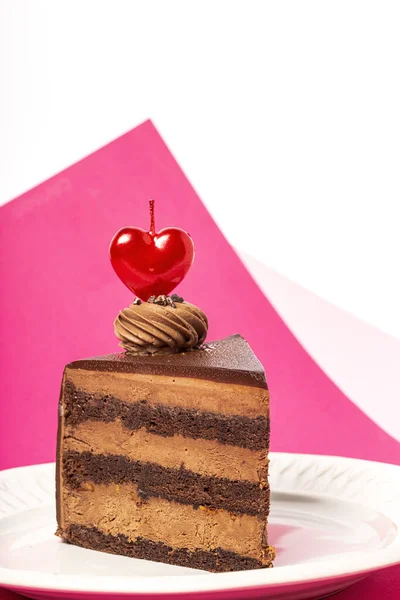 マゼンタとピンクの背景にバレンタインデーのためのハートキャンドルチョコレートケーキの背景 ストックフォト