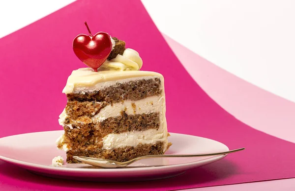 マゼンタとピンクの背景にバレンタインデーのためのハートキャンドルとニンジンケーキの背景 ストック画像