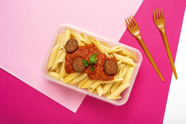 意大利通心粉 番茄酱 辣椒酱和奶酪 装在塑料容器里 随时可以吃 用洋红和粉红调味 图库图片