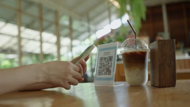 女人用智能手机扫描Qr代码 在没有现金的数字支付咖啡店里支付 选择菜单和订单累积折扣 电子钱包 网上支付 信用卡 银行应用软件 — 图库视频影像