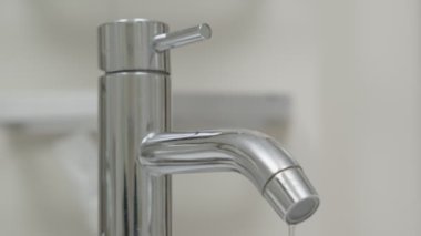 Banyoda musluk ve akan su. Su tasarrufu yapmak ve çevreyi korumak için suyu kapatmaya devam ediyor. küresel ısınma, yaşam, gelecek, risk enerjisi, kriz, su tasarrufu, dünya su günü.