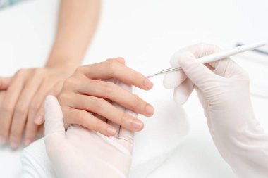 Kadın, güzellik merkezinde profesyonel güzellik manikürü ile bakım hizmeti alıyor. Güzellik salonunda jöle tedavisi için tırnak törpüsü kullanın. Manikürcü, çivi müşterisini güzelleştirir. vücut bakımı spa tedavisi