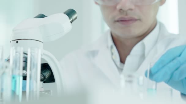 科学者は最先端の科学研究室で生化学試料を分析する 医療用顕微鏡はウイルスの微生物学的発達に見える 科学研究所のバイオテクノロジー研究 — ストック動画