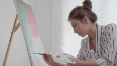 Profesyonel sanatçı, soyut sanat için boya hazırlar ve başyapıt yaratır. Stüdyoda suluboya ya da yağlı boya boya. Kadınlar resim yapmayı hobi olarak severler. iş eğlencesi, rahatlama, iş.