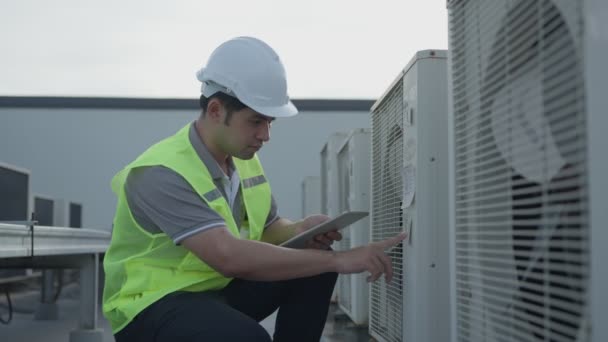 亚洲维修工程师在工厂的屋顶上工作 承办商对压缩机系统进行检查 并计划在施工中安装空调系统 在线查询 移动应用 — 图库视频影像