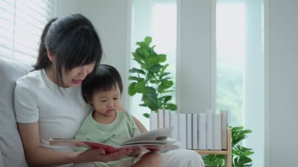 Feliz Madre Asiática Relajarse Leer Libro Con Bebé Tiempo Juntos — Vídeo de stock