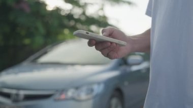 breakdown, broken car, repair. Man uses mobile phone check insurance premiums through application due to car accident . Find garage to get car fixed during country tour, waiting for help, emergency.