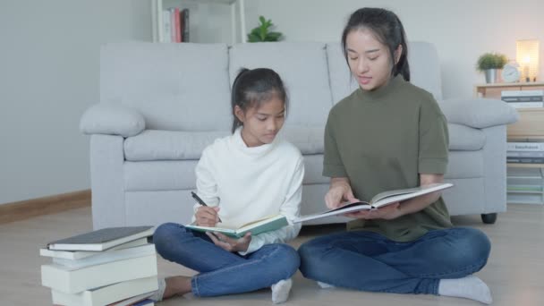 母亲为女儿授课 亚洲小女孩在家里学习 和慈祥的妈妈一起做作业 鼓励她考试 亚洲女孩快乐的家庭学校 妈妈建议一起接受教育 — 图库视频影像