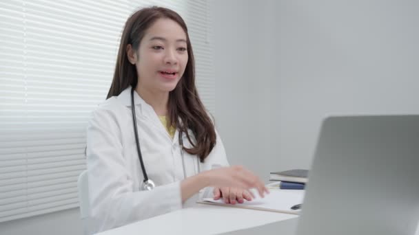 テレメディカル 医者はビデオ会議で患者に薬を説明します アジアの医師は 病気を説明しながら電気通信で患者を治療しています 健康技術 — ストック動画
