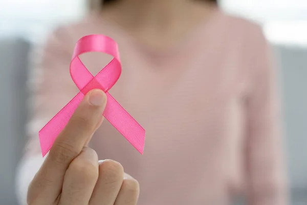 Woman hold pink ribbon breast cancer awareness. Female health check consciousness. international Women Day and World Cancer Day. sign cancer, Symbolic, health care, support patients, timely diagnosis