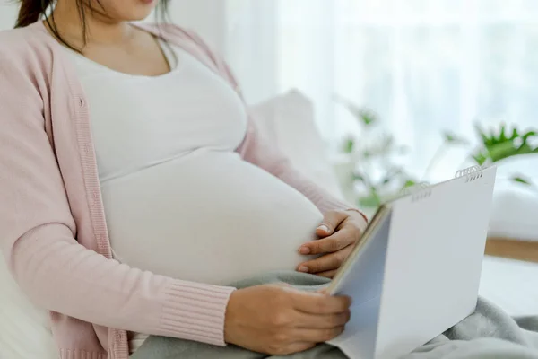 pregnant woman look schedule for due date of birth. Caesarean section is a way for pregnant to know a due date. prepare, newborn, developmental, monitor, appointment, maternity leave, gestational age