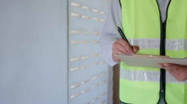 inspector or engineer is inspecting construction and quality assurance new house using a checklist. Engineers or architects or contactor work to build the house before handing it over to the homeowner