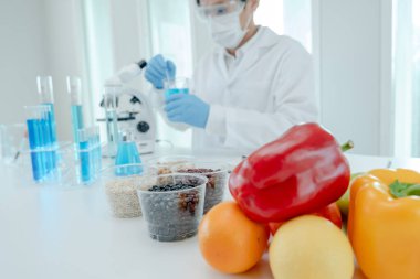 Scientist check chemical food residues in laboratory. Control experts inspect quality of fruits, vegetables. lab, hazards, ROHs, find prohibited substances, contaminate, Microscope, Microbiologist