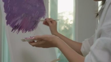 Profesyonel kadın sanatçı kız, sanat eseri yaratmak için soyut sanatlarda boya fırçası kullanır. Stüdyoda suluboya ya da yağlı boya boya. Güzel bir kadın resim yapmaktan zevk alır. iş eğlencesi