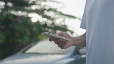 breakdown, broken car, repair. Man uses mobile phone check insurance premiums through application due to car accident . Find garage to get car fixed during country tour, waiting for help, emergency.