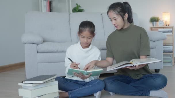 娘のための母語教師 アジア系の少女は家で学ぶ 親切な母親の助けを借りて宿題をし 試験を奨励してください アジアの女の子幸せな家庭学校 ママは一緒に教育に助言する — ストック動画