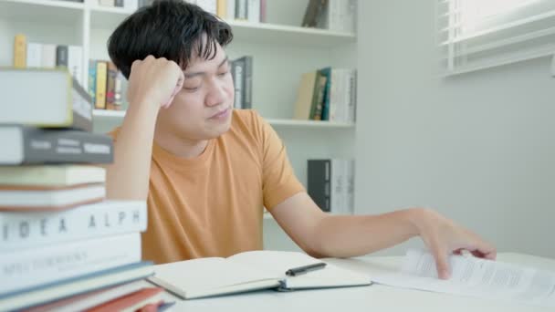 Asyalı Öğrenci Sınavlar Yüzünden Endişeli Erkek Öğrenci Kütüphanede Sınav Öğrenme — Stok video