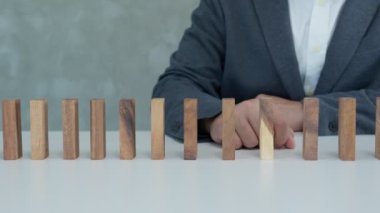 Domino 'yu elleri olan sigorta korur. İş adamı elleri iş krizinde domino taşlarının düşmesini durdurur. işletme risk denetimi ve planlama ve işletmeler sigorta işletmelerini önlemek için stratejiler.