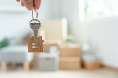 Moving house, relocation. The key was inserted into the door of the new house, inside the room was a cardboard box containing personal belongings and furniture. move in the apartment or condominium