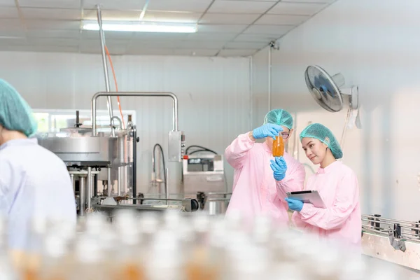 A quality supervisor or food or beverages technician discuss about process control of food and drugs before send product to the customer. Production leader recheck ingredient and productivity.