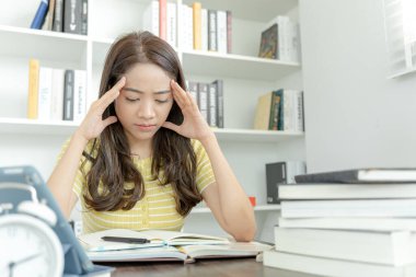 Asian student woman have anxiety because of exams, female prepare for test and learning lessons in the library. stress, despair, haste, misunderstanding reading, discouraged, expectation, knowledge