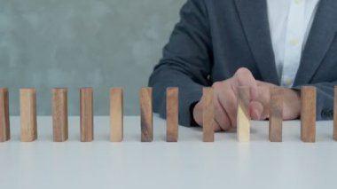 Domino 'yu koruyan bir sigorta. İş adamı iş krizinde domino taşlarının düşmesini durdurdu. işletme risk denetimi ve planlama ve işletmeler sigorta işletmelerini önlemek için stratejiler.
