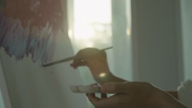 Profesyonel kadın sanatçı kız, sanat eseri yaratmak için soyut sanatlarda boya fırçası kullanır. Stüdyoda suluboya ya da yağlı boya boya. Güzel bir kadın resim yapmaktan zevk alır. iş eğlencesi