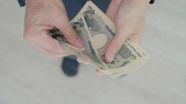 Japon Yen parası. Japon yenini elinizin altında tutun. Japonya 'nın değişim, alım, satım, birikim, yatırım, finans, döviz kuru, değer, muhasebe, uluslararası döviz kurunda kullanılan para birimi