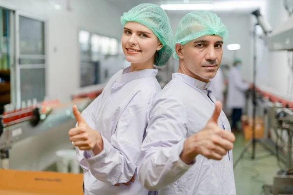 portrait quality supervisor or food or beverages technician team thumbs up quality control food or beverages before send product to the customer. Production leader , Quality assurance, staff team.